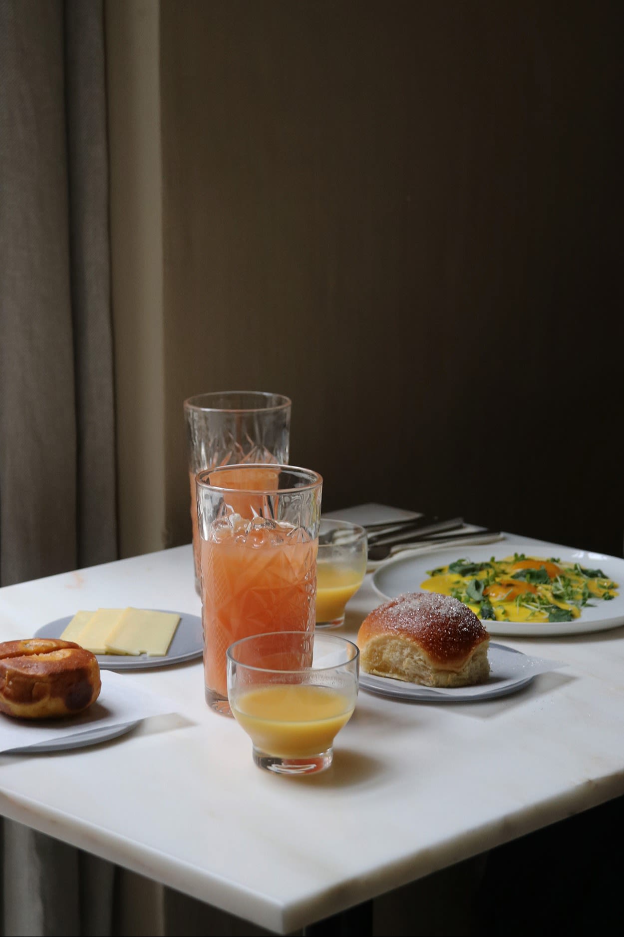 Una mesa con comida y bebida en el restaurante Audo de Copenhague. Es el lugar ideal para tomar un bocado a la hora de comer para cualquier amante del diseño de visita en Copenhague. 