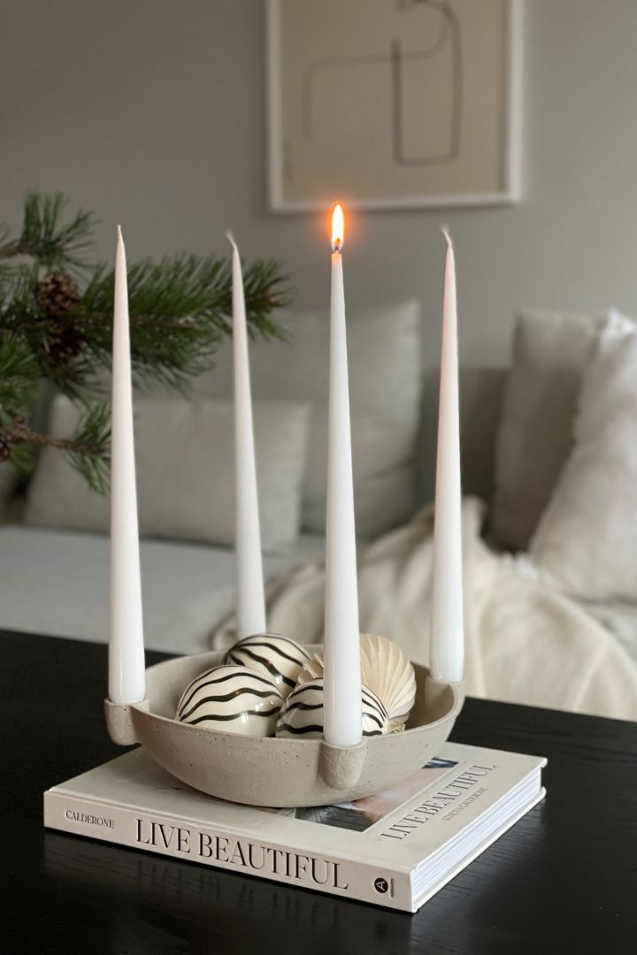 Cómo decorar con adornos navideños tradicionales escandinavos: el candelabro de Adviento Bowl en beige de Scandi Living es un elegante portavelas que luce tan acogegdor en el mueble de la entrada como en la mesa del comedor. Visto aquí en el hogar de @myjapandihome.