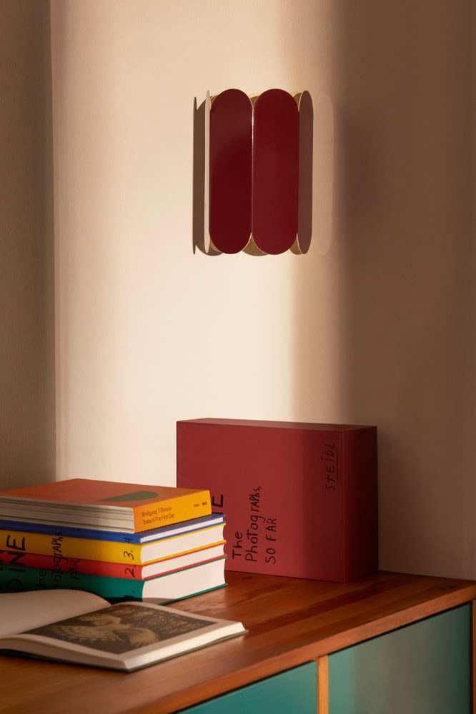 La lámpara de pared Arc en el tono rojo favorito de esta temporada. Los bordes ondulados son la actualización perfecta para cualquier hogar con estas ideas de iluminación moderna.