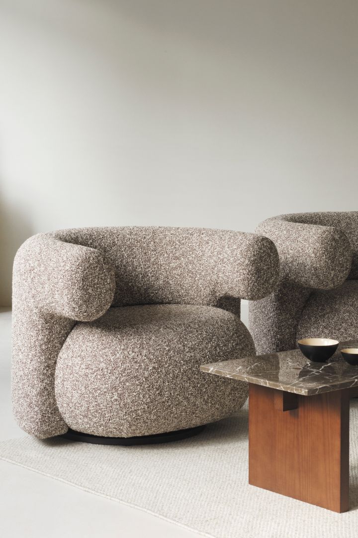 El robusto y macizo sillón Burra de Normann Copenhagen, aquí con una mesa de centro de madera con tablero de granito, ambos perfectos según las tendencias de interior de otoño de 2024 y con un diseño macizo.