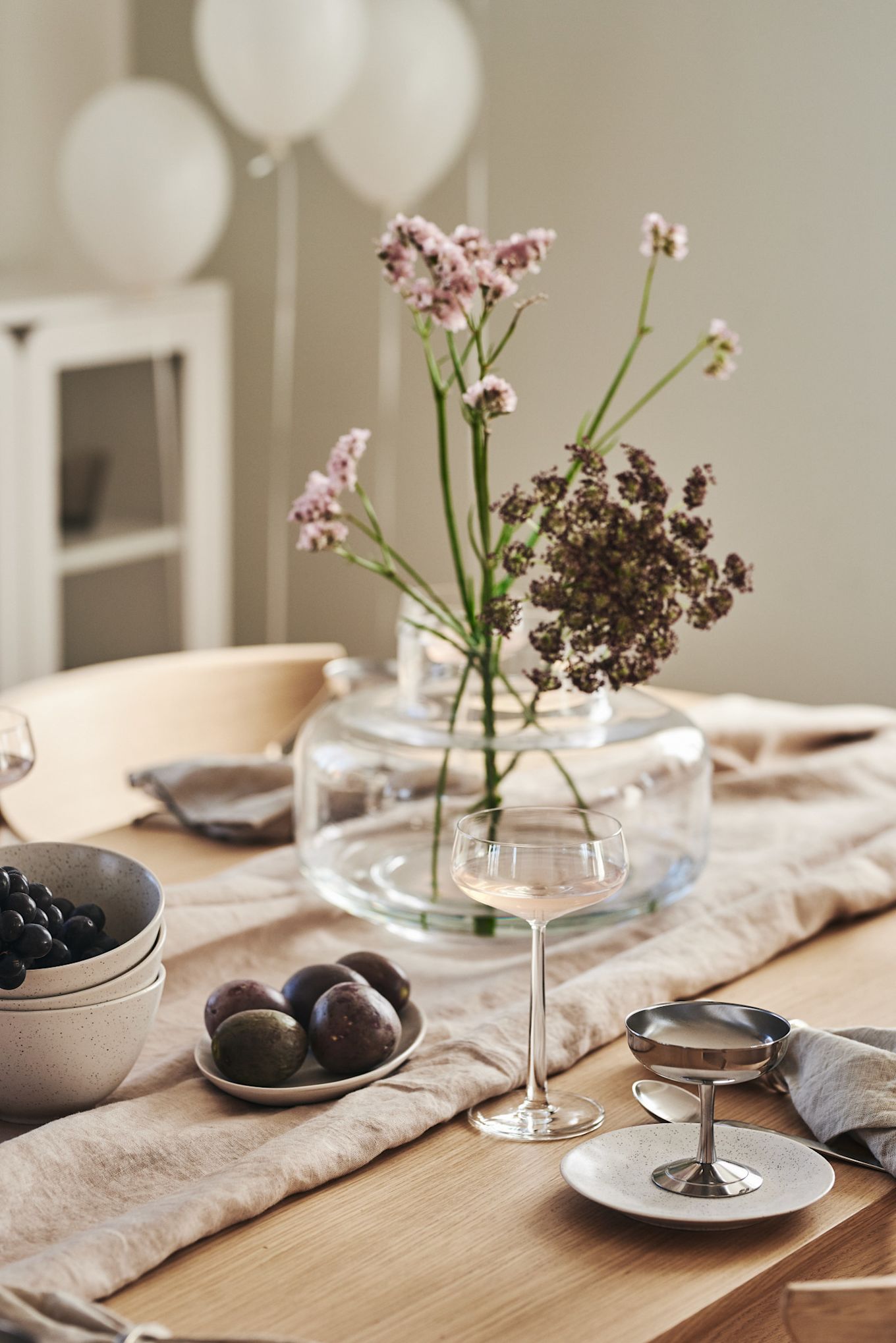 Una cena romántica en casa también incluye la decoración adecuada de la mesa. Aquí se presenta una mesa elegantemente sencilla, con copas de la colección Essence de Iittala y un jarrón con flores, creando un ambiente íntimo y sofisticado.