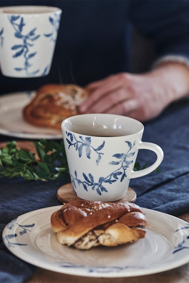 Un típico fika sueco con café y rollos de canela, servido en porcelana azul y blanca de Scandi Living.