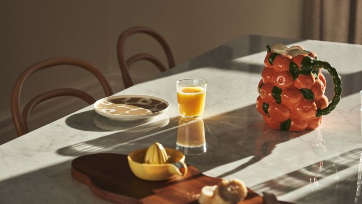 Mesa puesta con vajilla de Marimekko, zumo y jarra de BYON con diseño de mandarinas.
