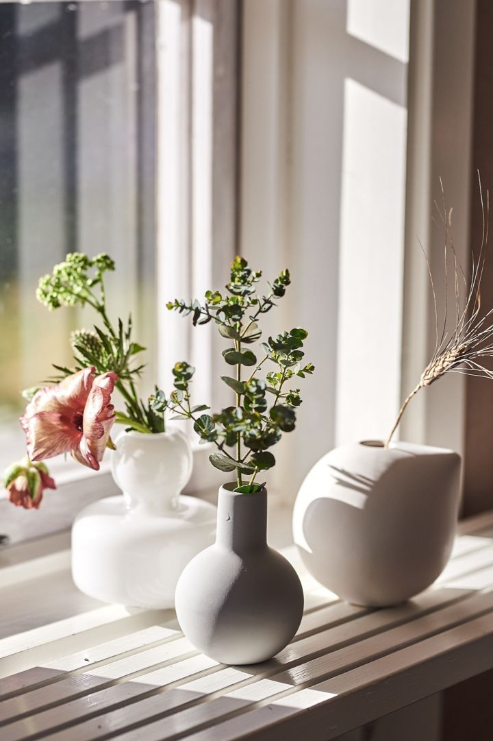 En el alféizar de una ventana se colocan varios jarrones pequeños para flores individuales o pequeños ramos. 