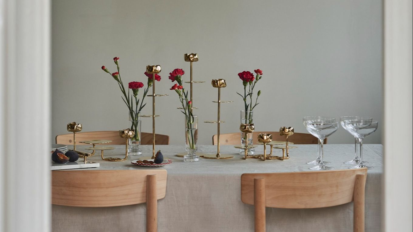 Aquí puedes ver una mesa decorada con candelabros Hilke y flores rojas.