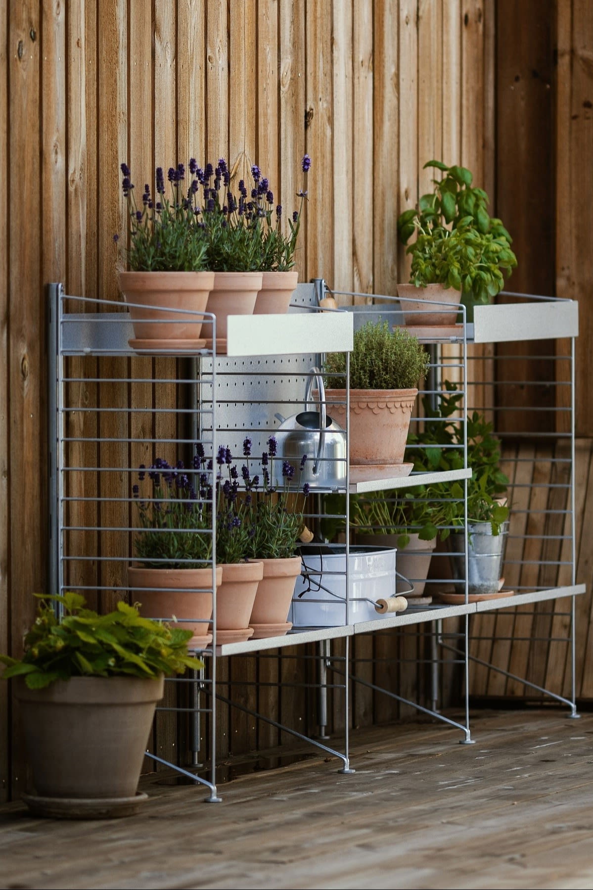 Una estantería exterior de String en la terraza de @applaudden, decorada con varias plantas en macetas Bergs Potter de la colección Copenhague.