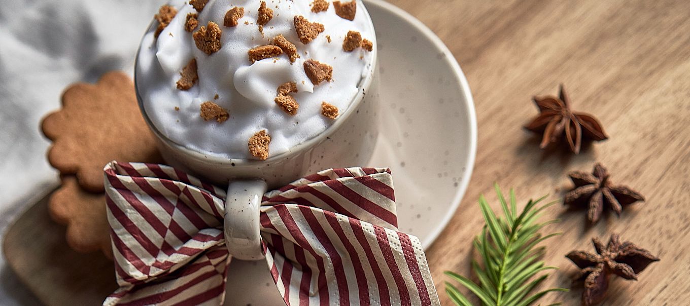 Ofrece un cóctel navideño sencillo con café, galleta de jengibre y canela en una taza Freckle de Scandi Living, acompañado de una servilleta Lines de Cooee Design en forma de lazo.