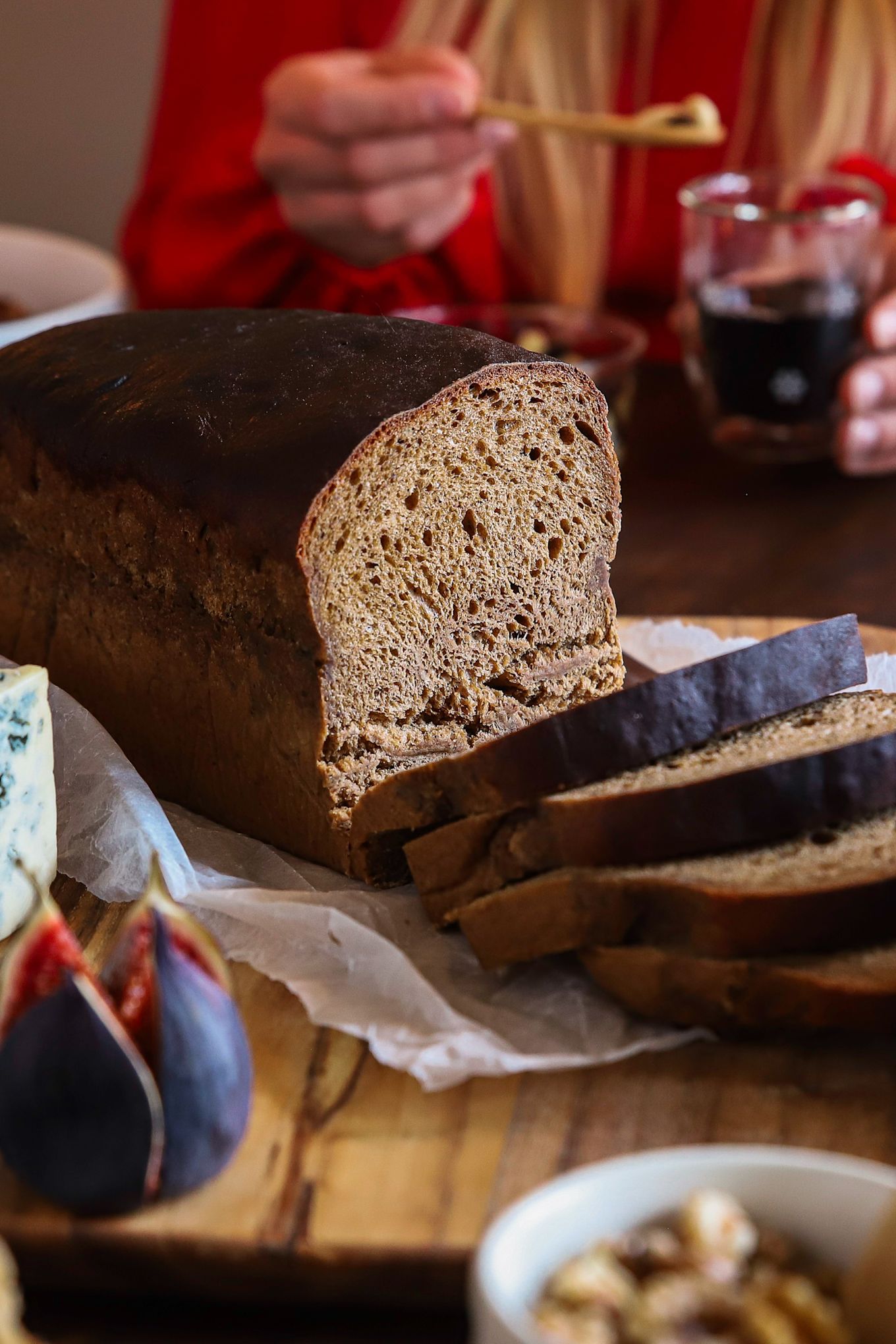 Recetas de repostería navideña de Baka med Frida: un clásico pan sueco de vört, servido en una tabla de cortar de madera con queso azul e higos.