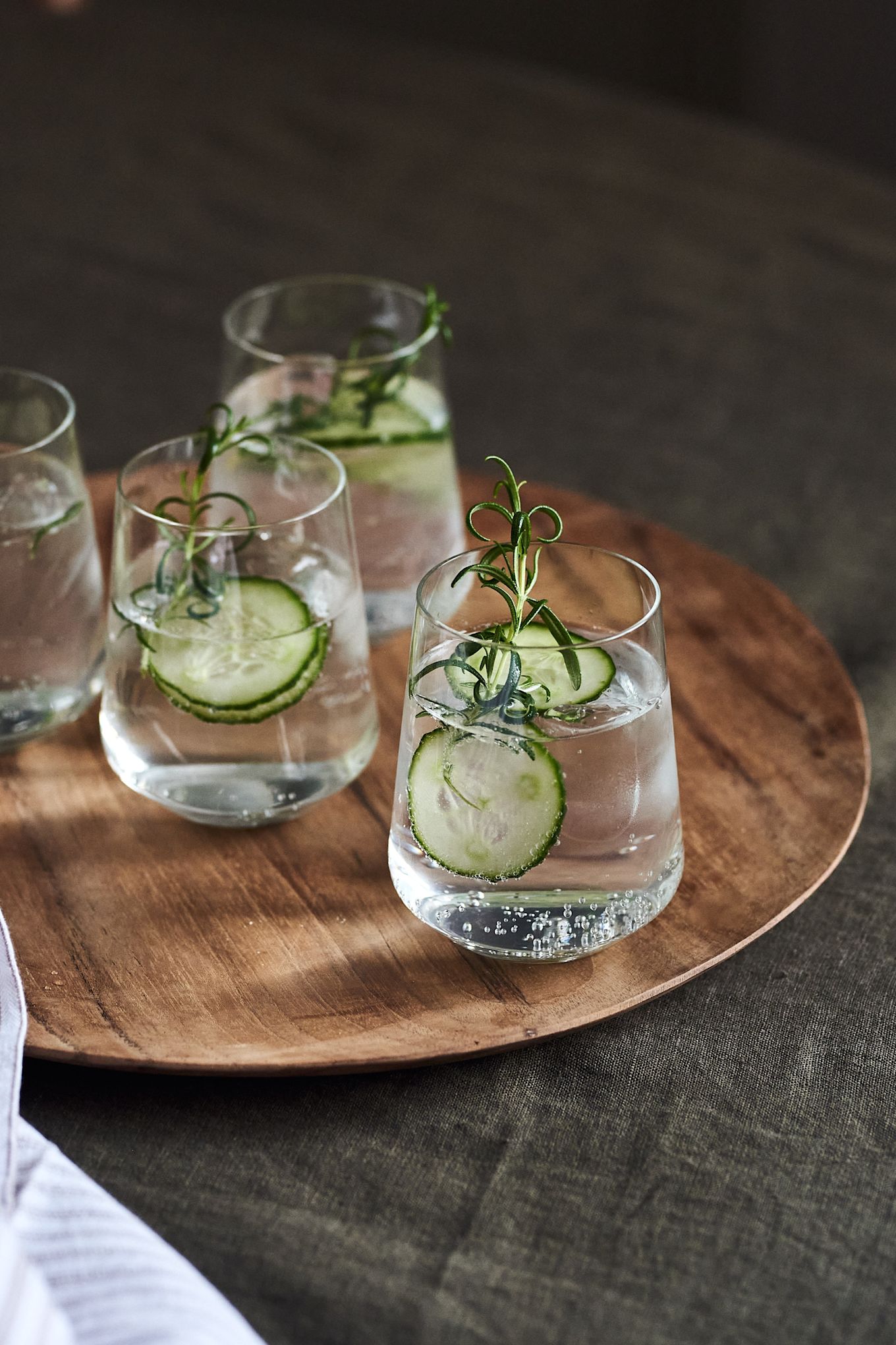 5 recetas de cócteles festivos para año nuevo: vaso de agua Iittala Essence en plato Muubs Teak.