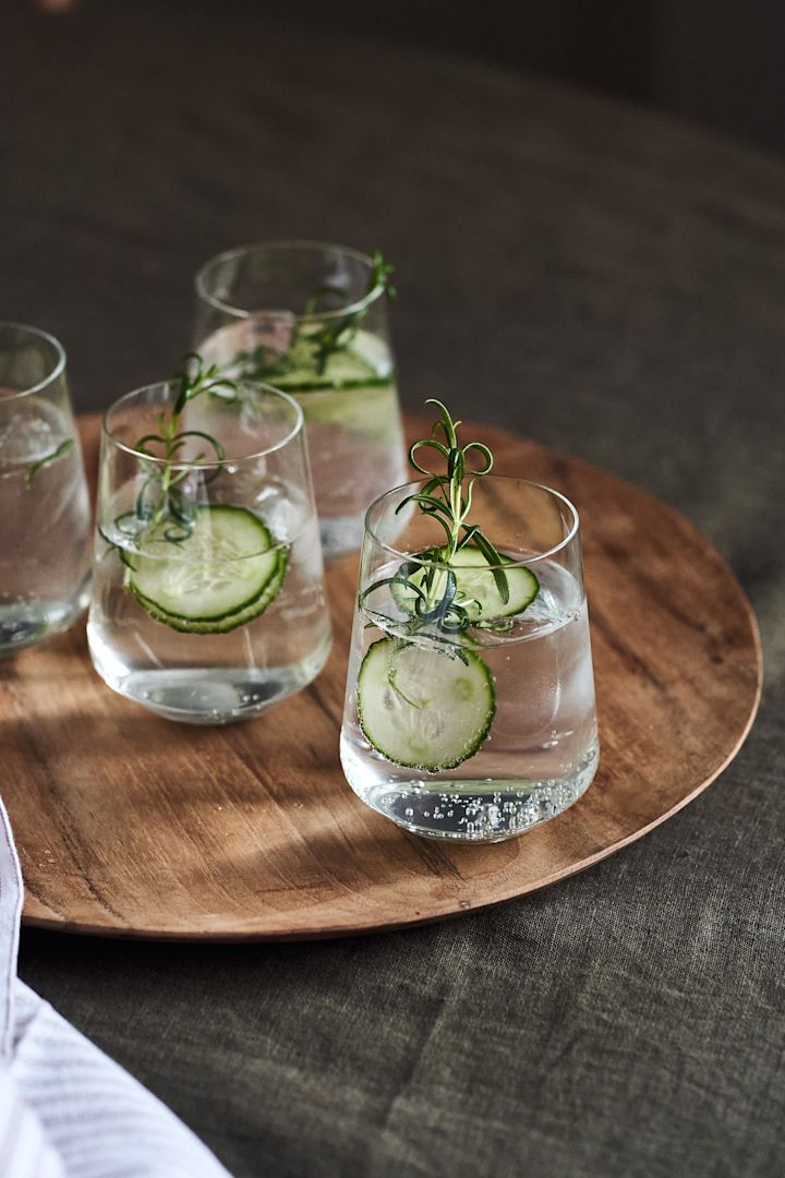 5 recetas de cócteles festivos para año nuevo: vaso de agua Iittala Essence en plato Muubs Teak.