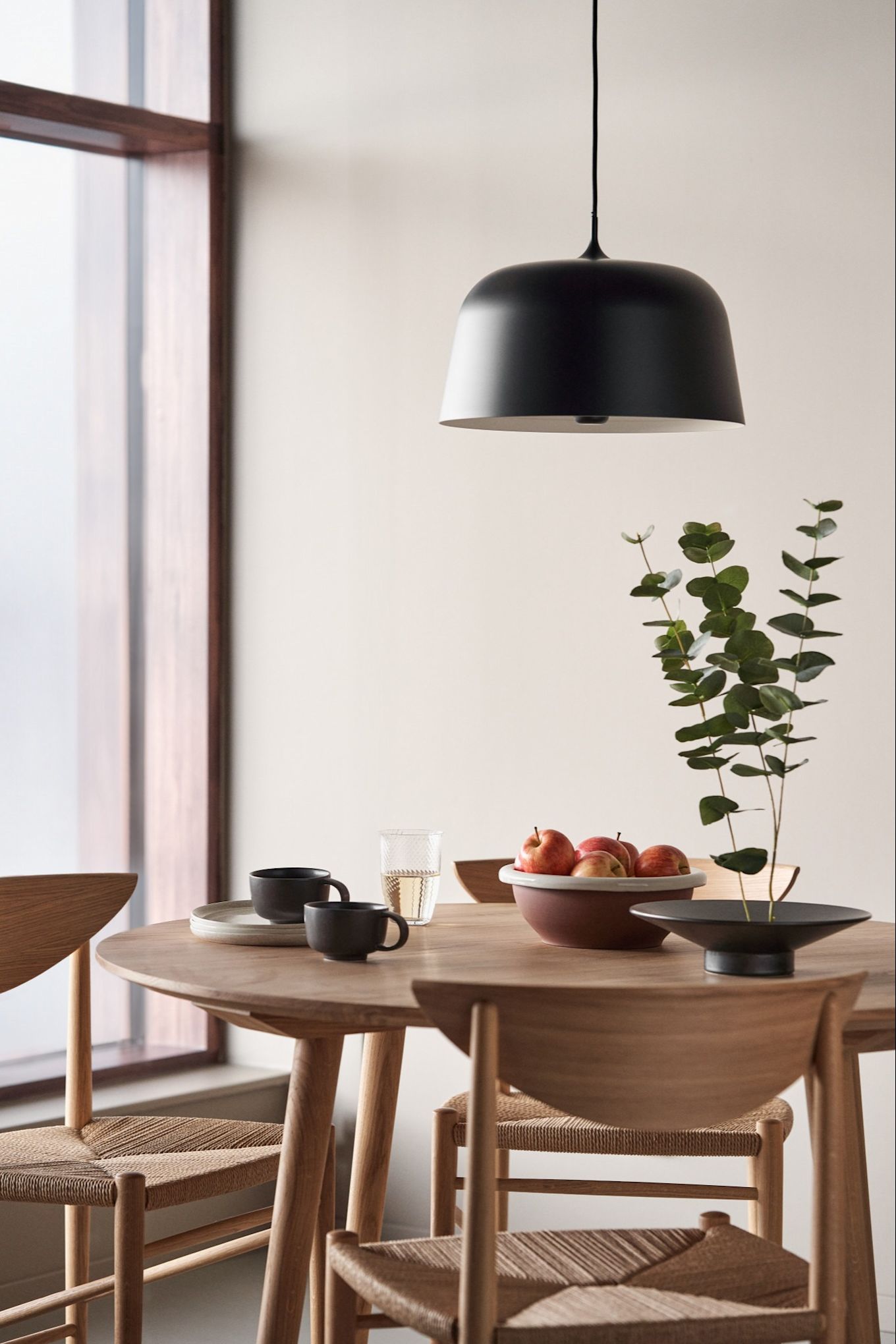 Renueva tu hogar con iluminación moderna para el techo. Aquí puedes ver la lámpara de techo Halo de Scandi Living en color negro, colgando sobre una mesa de comedor redonda.