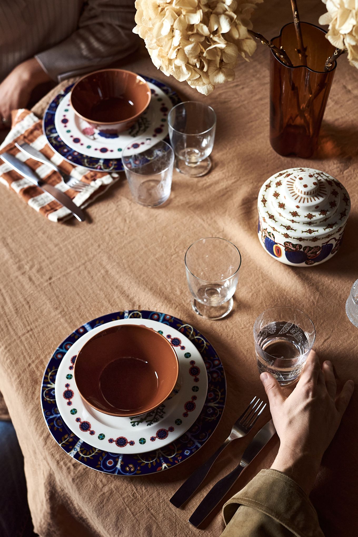 Una idea de decoración de mesa bohemia, aquí puedes ver una mesa en tonos marrones y azules con la vajilla estampada Taika.