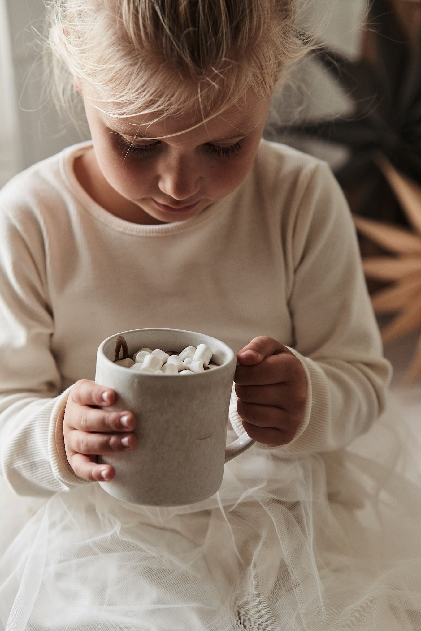 Cosas del estilo de vida escandinavo que tienes que probar este invierno: ¡Preparar chocolate caliente con los más pequeños! Aquí puedes ver a una niña con la taza Sandsbro de Scandi Living.