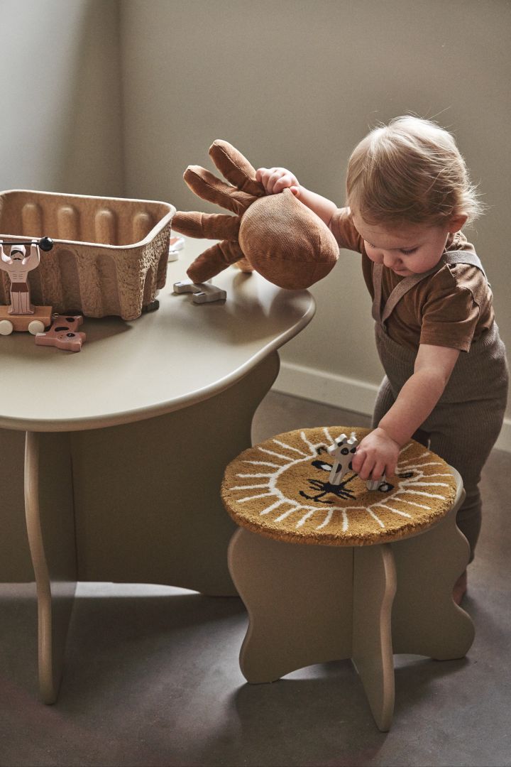 Una mesa y los taburetes que la acompañan son perfectos para decorar las habitaciones infantiles, donde los más pequeños pueden sentarse y dibujar, hacer manualidades o construir. Aquí vemos la mesa y el taburete Slope en color cashmere de Ferm Living.