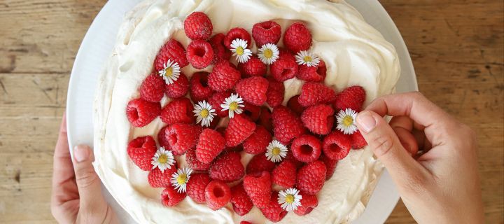 Un delicioso pastel de merengue es una de las sencillas recetas de pasteles de Baka med Frida. Decora el pastel de merengue y nata con frambuesas rojas frescas y margaritas.