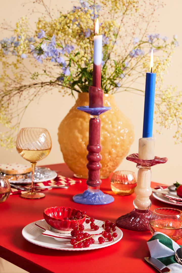 Imagen que muestra la colección de otoño de Byon y el tema Fall in love de la colorida mesa en rojo apasionado y de los cristales de colores en forma de cristal Oparicy en marrón y jarrón Corallo en amarillo y candelabros Lara en burdeos, violeta y beige.