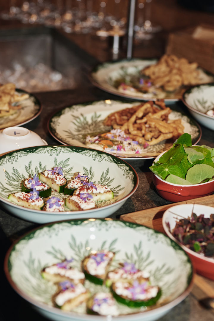 Aquí puedes ver el plato hondo Ostindia Floris con una presentación profesional de la comida. Forma parte de una idea de decoración de mesa en verde para lograr un ambiente de restaurante en casa.