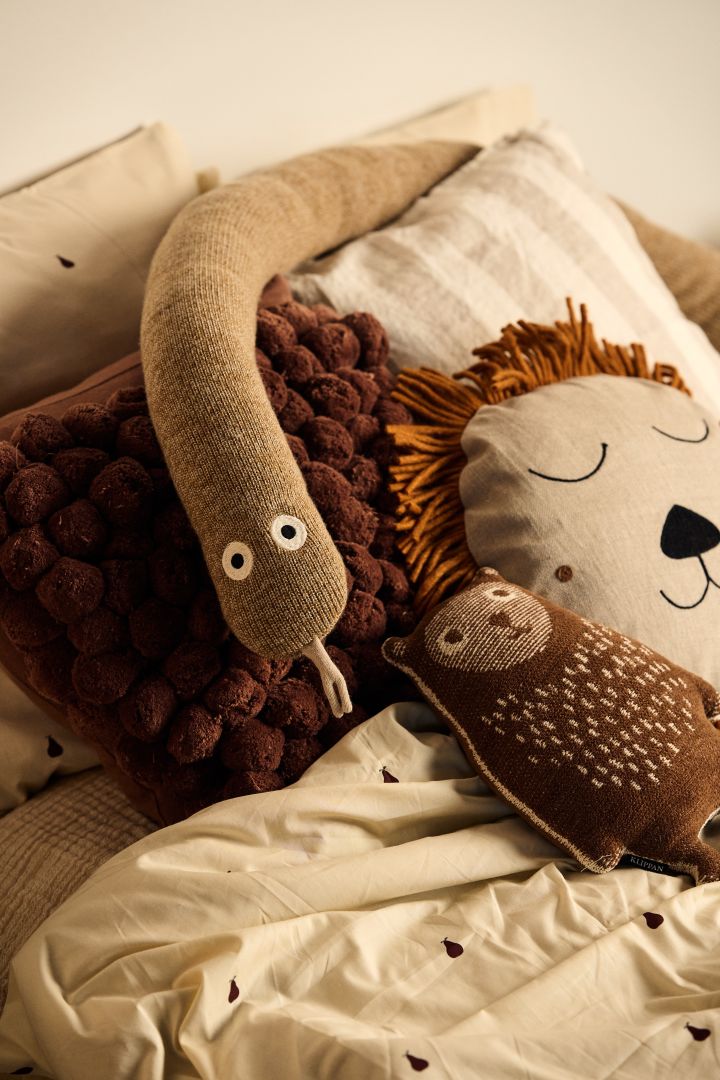 Decorar las habitaciones infantiles con decoraciones que favorezcan el juego hace que sea más fácil crear una habitación que sea a la vez elegante y libre para jugar. Aquí el peluche de serpiente Mr Snake junto con la almohada Safari, ambos de Ferm Living.