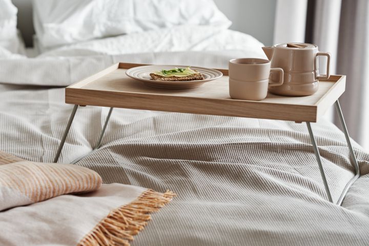 La porcelana beige táctil de NJRD es el acompañamiento perfecto para el desayuno en la cama junto con una suave manta de algodón reciclado. 