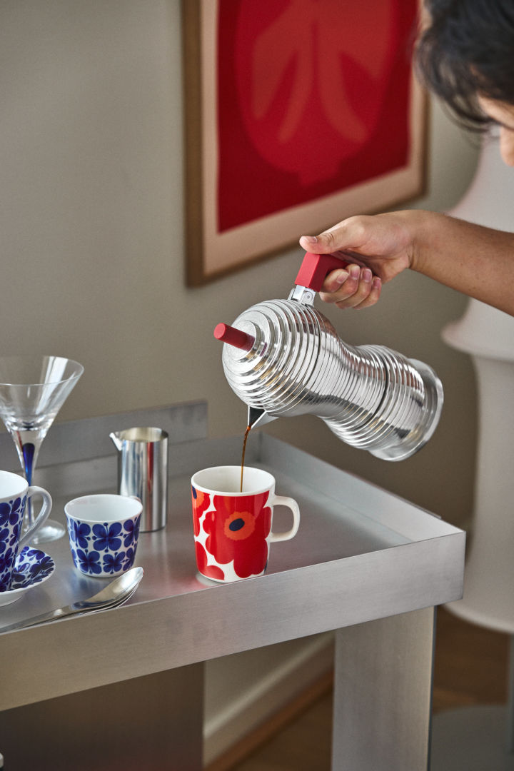 Un buen rincón del café también necesita una máquina de espresso adecuada. Aquí puedes ver una mano sirviendo café de la máquina de espresso Pulcina de Alessi en una taza de Marimekko.