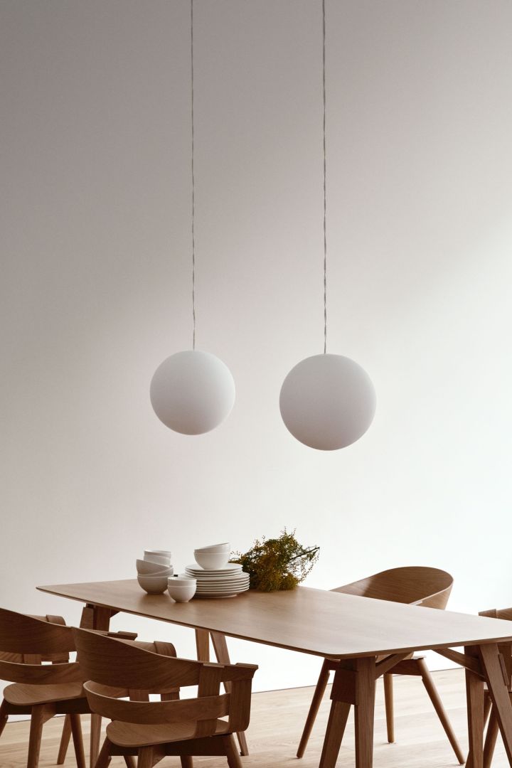 Aquí puedes ver la lámpara de diseño escandinavo Luna, de Design House Stockholm, colgada sobre una mesa de comedor. 