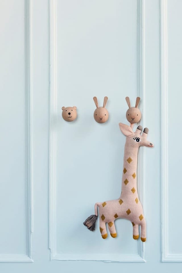 Los complementos especialmente prácticos para la vida cotidiana son una opción popular para los regalos de baby shower. Aquí puedes ver los pequeños ganchos de pared con forma de oso y conejo de OYOY, que garantizan que las cosas importantes estén siempre fácilmente accesibles para los nuevos padres, como la jirafa Baby Guggi, también de OYOY.