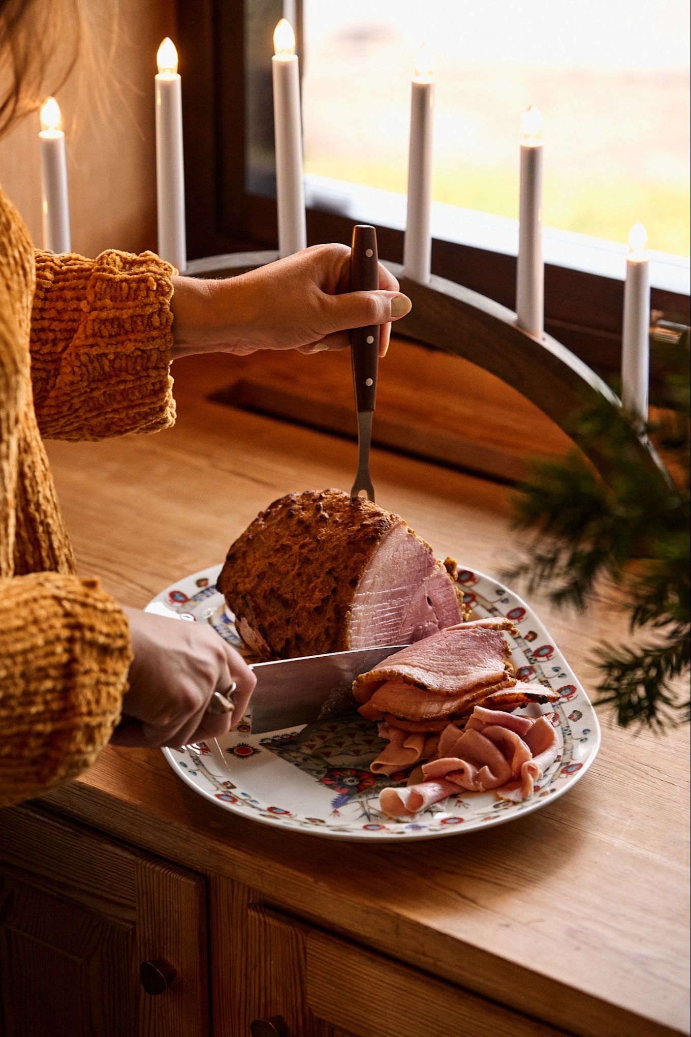 El jamón navideño se sirve en una hermosa porcelana de Iittala, preparándose para la próxima cena de Navidad.