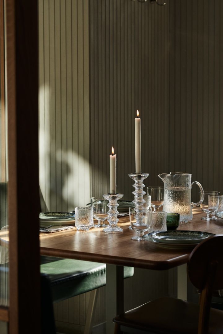 Aquí puedes ver una idea de decoración de mesa en verde en un entorno de restaurante, con portavelas de vidrio grueso y una jarra de agua a juego.