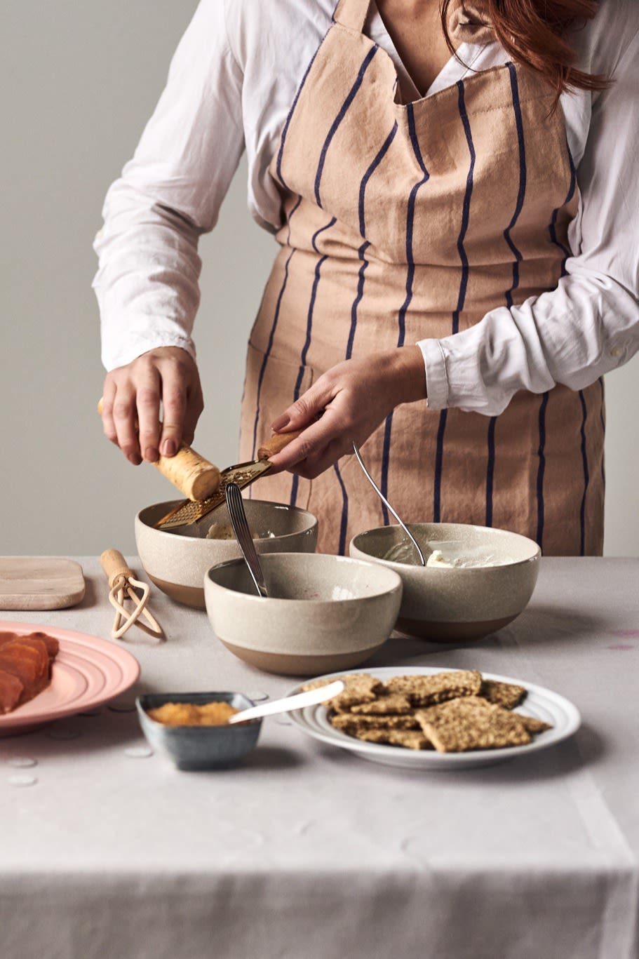 Rallar rábano picante con el rallador de latón Bloomingville en un bol Scandi Living Fossil para una de las 5 sencillas recetas de entrantes que hay que probar este nuevo año.