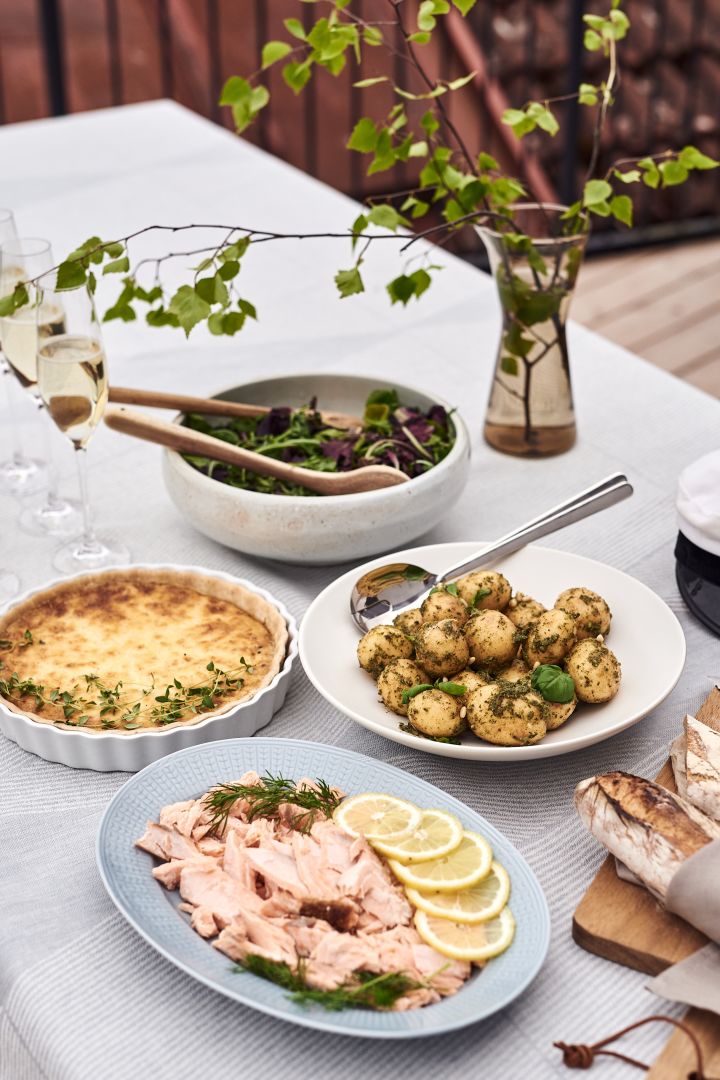 Un bufé de salmón ahumado caliente, pastel de Västerbotten, ensalada de patata al
pesto, hojas de ensalada fresca y pan crujiente caliente para el menú de tu fiesta de
verano en el jardín.