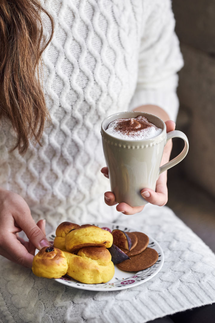 Sirve los tradicionales lussekatter en platos Swedish Grace Winter de Rörstrand y disfruta de una taza de chocolate caliente en una taza Dots de Scandi Living.